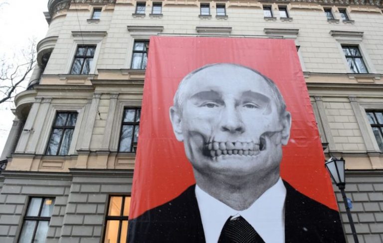 Un poster cu portretul lui Putin sub forma unui craniu,expus pe faţada unui muzeu din Riga