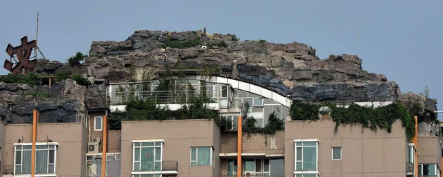 VIDEO – Când nebunia nu are limite: Un profesor și-a construit un munte pe acoperișul unui bloc de apartamente